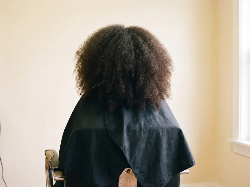 Antes — cabello afro sin tratar, seco y sin definición, visto desde atrás