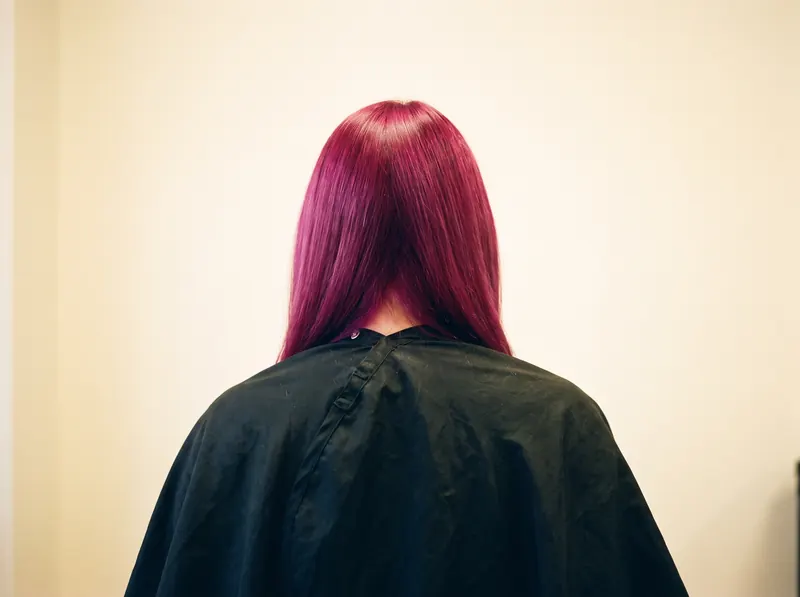 Después — el mismo cabello teñido de magenta intenso